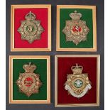 A collection of four reproduction brass military helmet plates including West Kent,