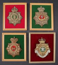 A collection of four reproduction brass military helmet plates including West Kent,