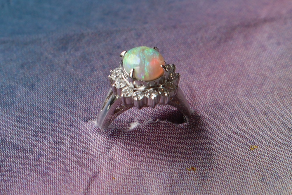 An opal and diamond ring set with a cabochon oval opal and a halo of round brilliant cut diamonds - Image 3 of 6