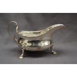 An Edward VII silver sauce boat, with a flared rim, on three legs and pad feet, Sheffield, 1908,