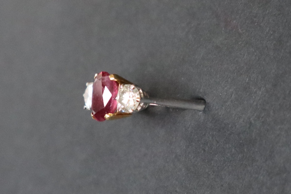 A ruby and diamond ring set with a central oval faceted ruby, approximately 9mm x 6mm, - Bild 3 aus 12