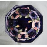 A Moorcroft pottery bowl of octagonal form, decorated with pansies to a royal blue ground,