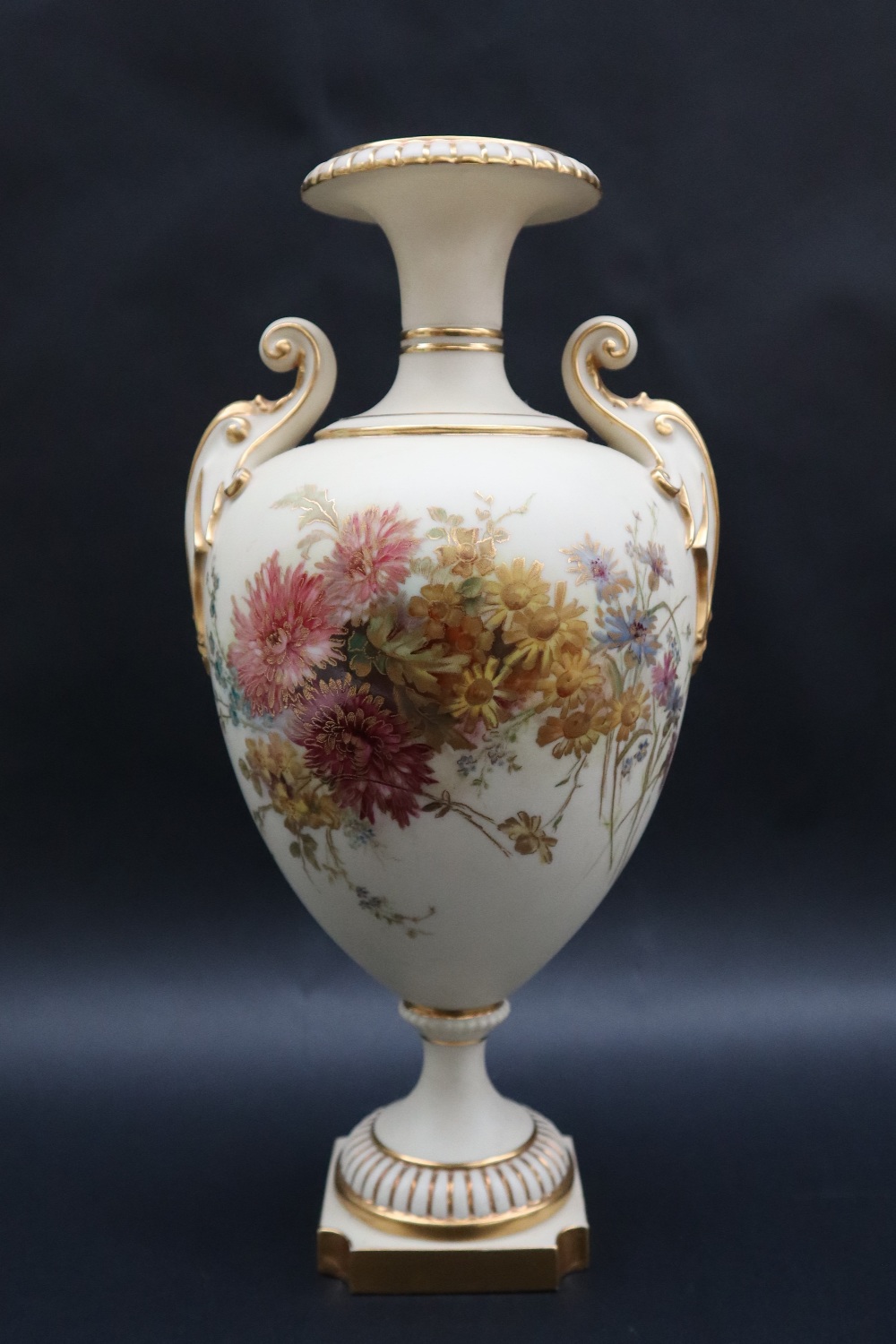 A large Royal Worcester twin handled vase with a flared rim and scrolling handles,