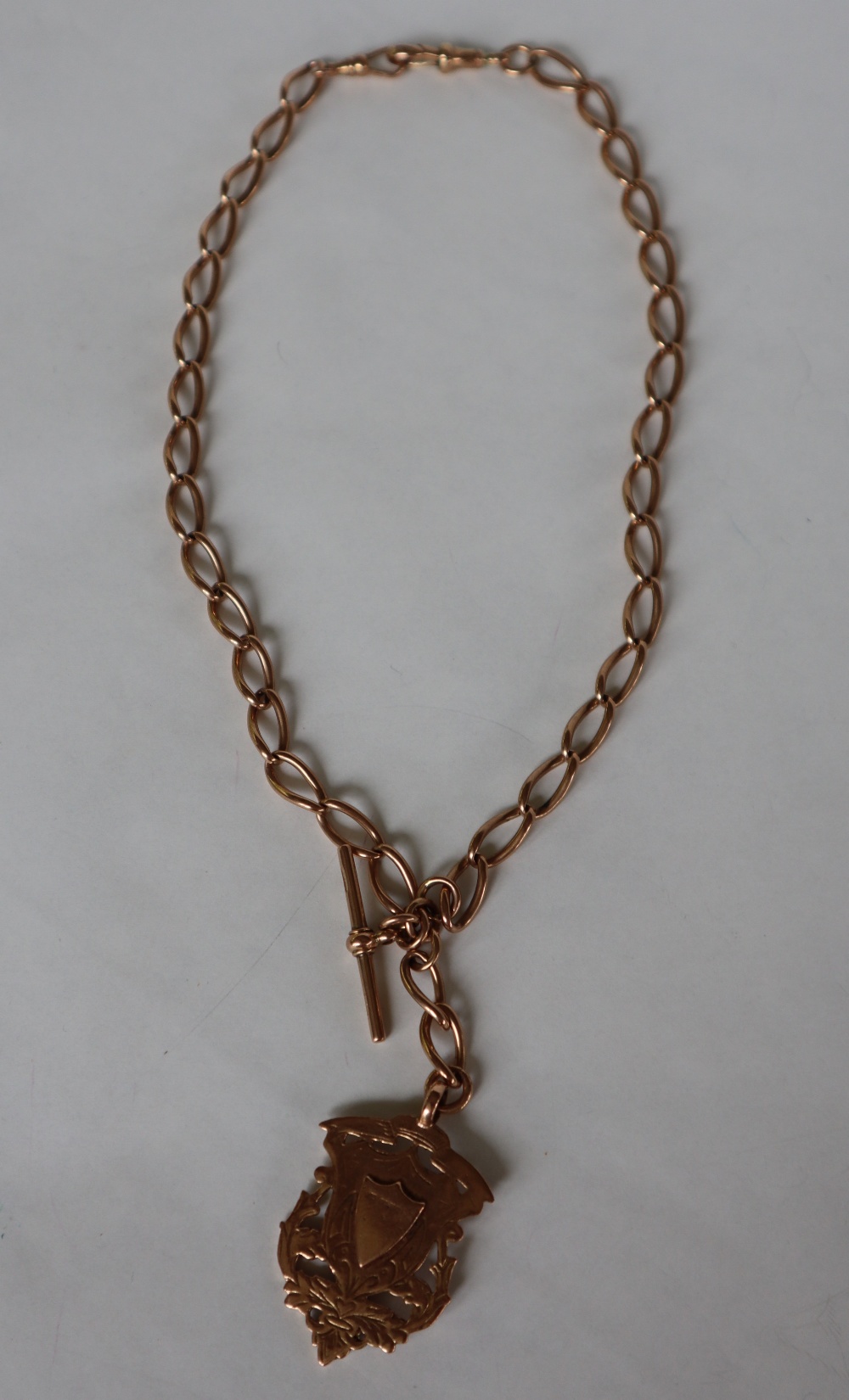 A 9ct yellow gold double Albert watch chain with twisted oval links and a 9ct gold shield medallion, - Bild 2 aus 6