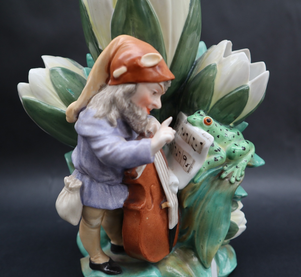 A continental porcelain triple lily vase moulded with a bearded sprite playing a cello with the - Image 3 of 9