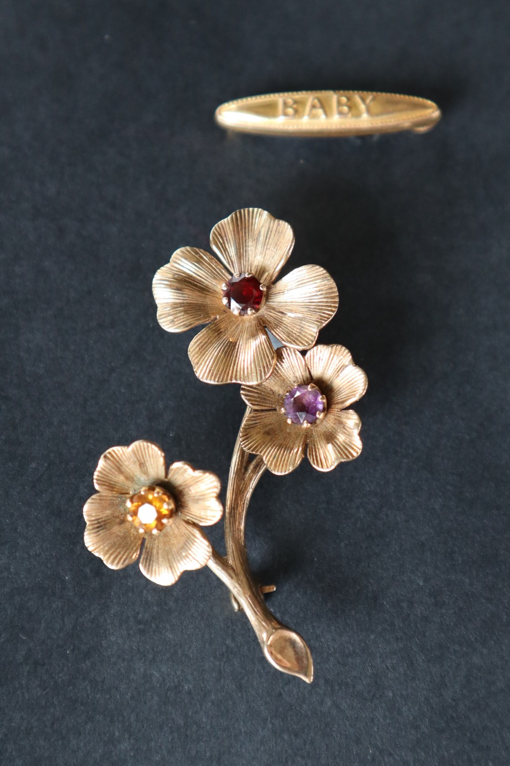 A 9ct gold brooch of floral form set with a garnet,