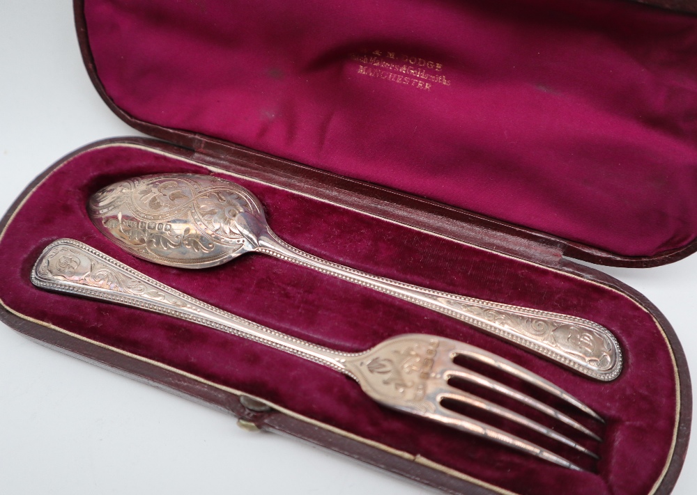 A Victorian silver christening set of a spoon and fork, with scrolling decoration, Sheffield, 1871,