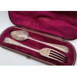 A Victorian silver christening set of a spoon and fork, with scrolling decoration, Sheffield, 1871,