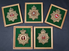 A collection of five reproduction brass military helmet plates including East Yorkshire,