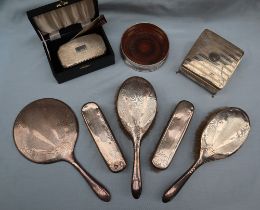 A George V silver backed part dressing table set including a hand mirror,
