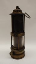 A Thomas and Williams of Aberdare Fireman's safety lamp with a domed top and pierced metal cylinder,