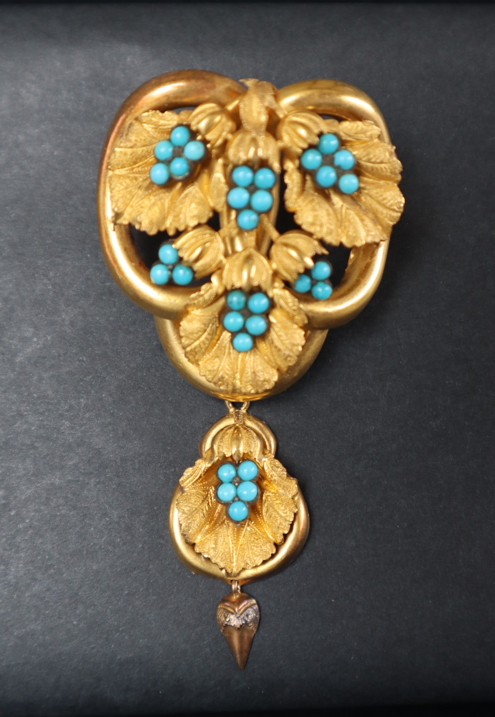 A Victorian yellow metal brooch in the form of three interlaced rings set with vine leaves and