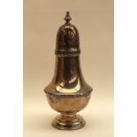 A George V silver sugar caster, with a turned finial and domed top with pierced decoration,