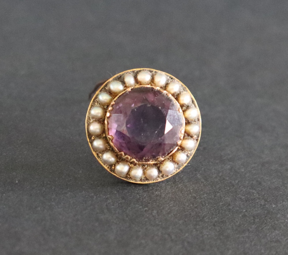 An amethyst and seed pearl brooch of circular form to a yellow metal setting, 25mm diameter,