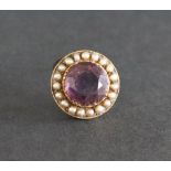 An amethyst and seed pearl brooch of circular form to a yellow metal setting, 25mm diameter,