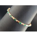 An emerald and diamond tennis bracelet set with sixteen oval faceted emeralds and diamonds to a