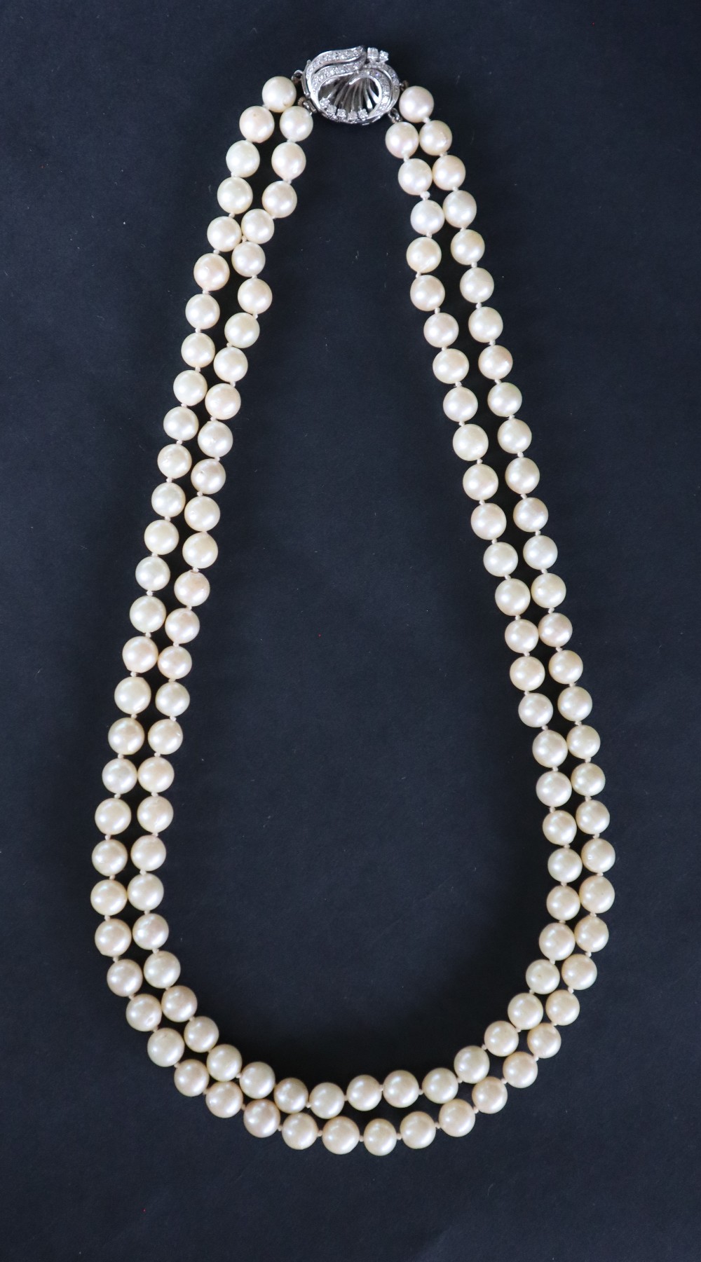 A double strand pearl necklace set with one hundred and twenty one regular pearls to a white metal