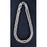 A double strand pearl necklace set with one hundred and twenty one regular pearls to a white metal