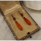 A pair of amber drop earrings, mounted in white metal,
