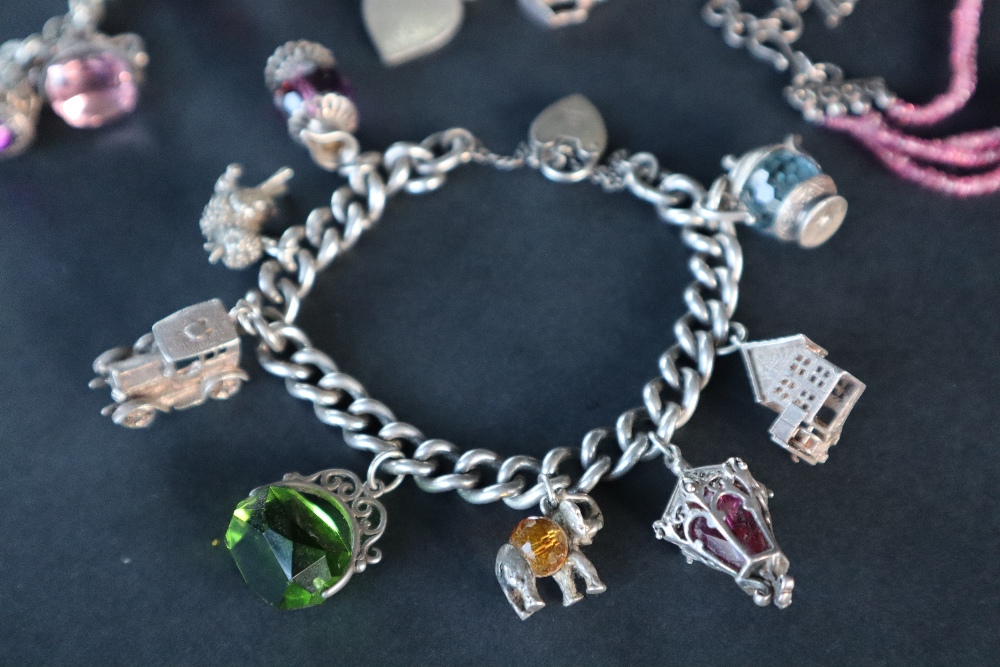 A silver charm bracelet set with numerous charms including a carriage, bird, - Image 4 of 6