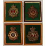 A collection of four reproduction brass military helmet plates including North Staffordshire,