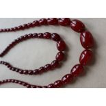 Two Cherry Amber / bakelite bead necklaces, ranging in size from 30mm to 10mm, 79cm long,
