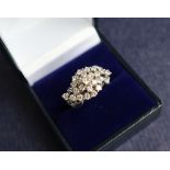 A diamond cluster ring set with round old cut diamonds to a white metal setting and shank, size O,