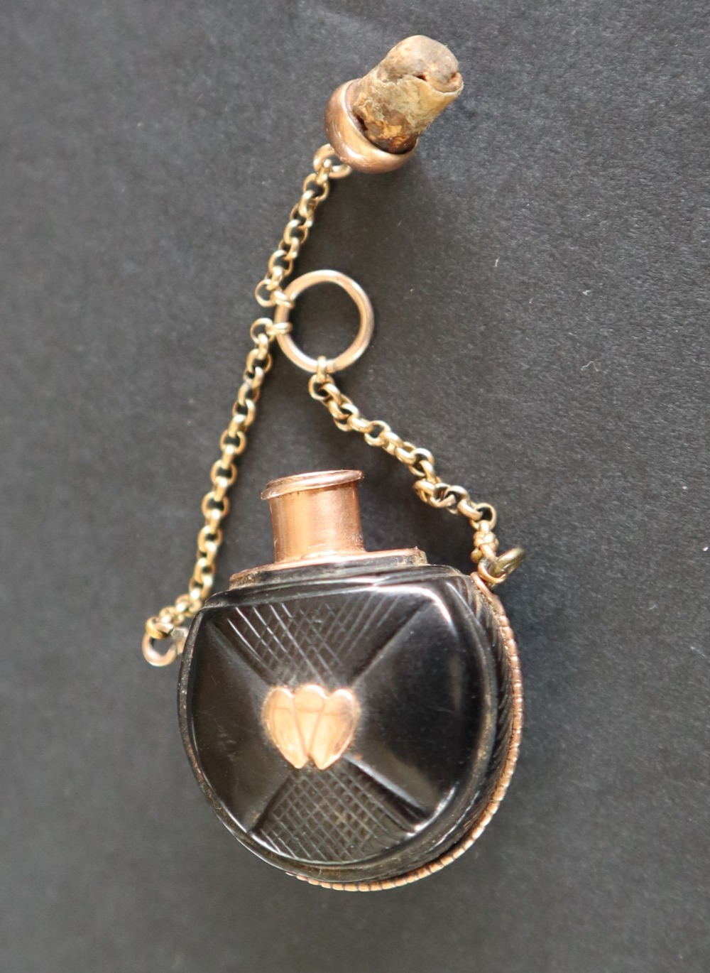 A small scent bottle the ebonised body inset and mounted in yellow metal on a chain - Image 3 of 4