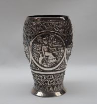 An Indian white metal beaker, decorated with figures, elephant, lion, flowers, leaves etc,