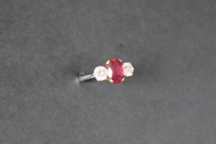 A ruby and diamond ring set with a central oval faceted ruby, approximately 9mm x 6mm,