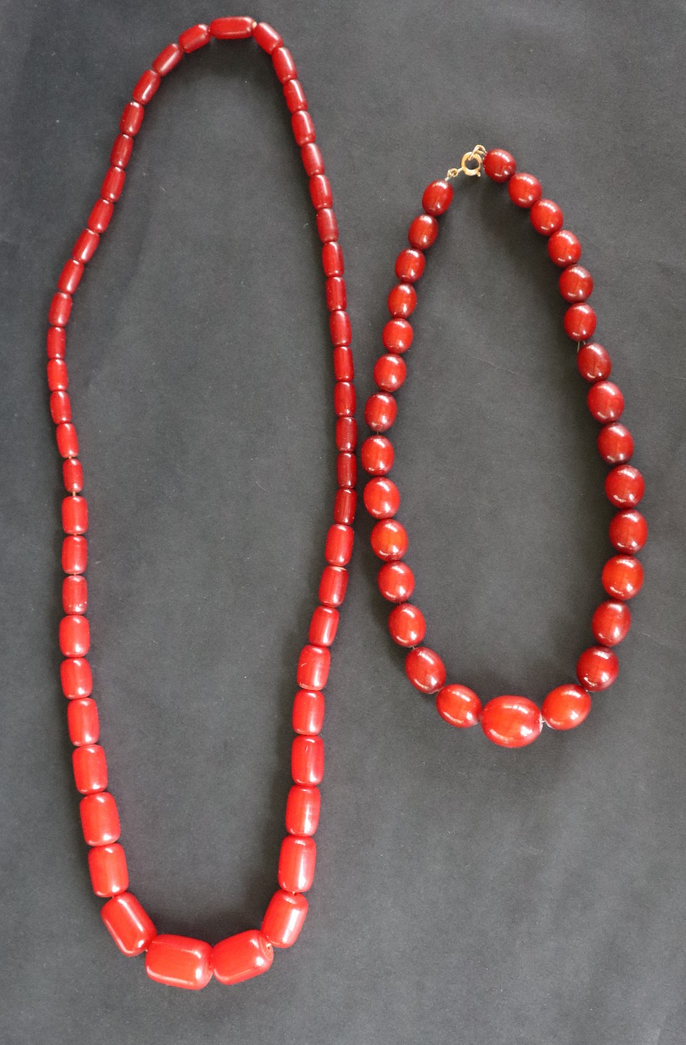 A Cherry Amber / Bakelite bead necklace, with barrel shaped beads ranging in size from 27mm to 15mm,