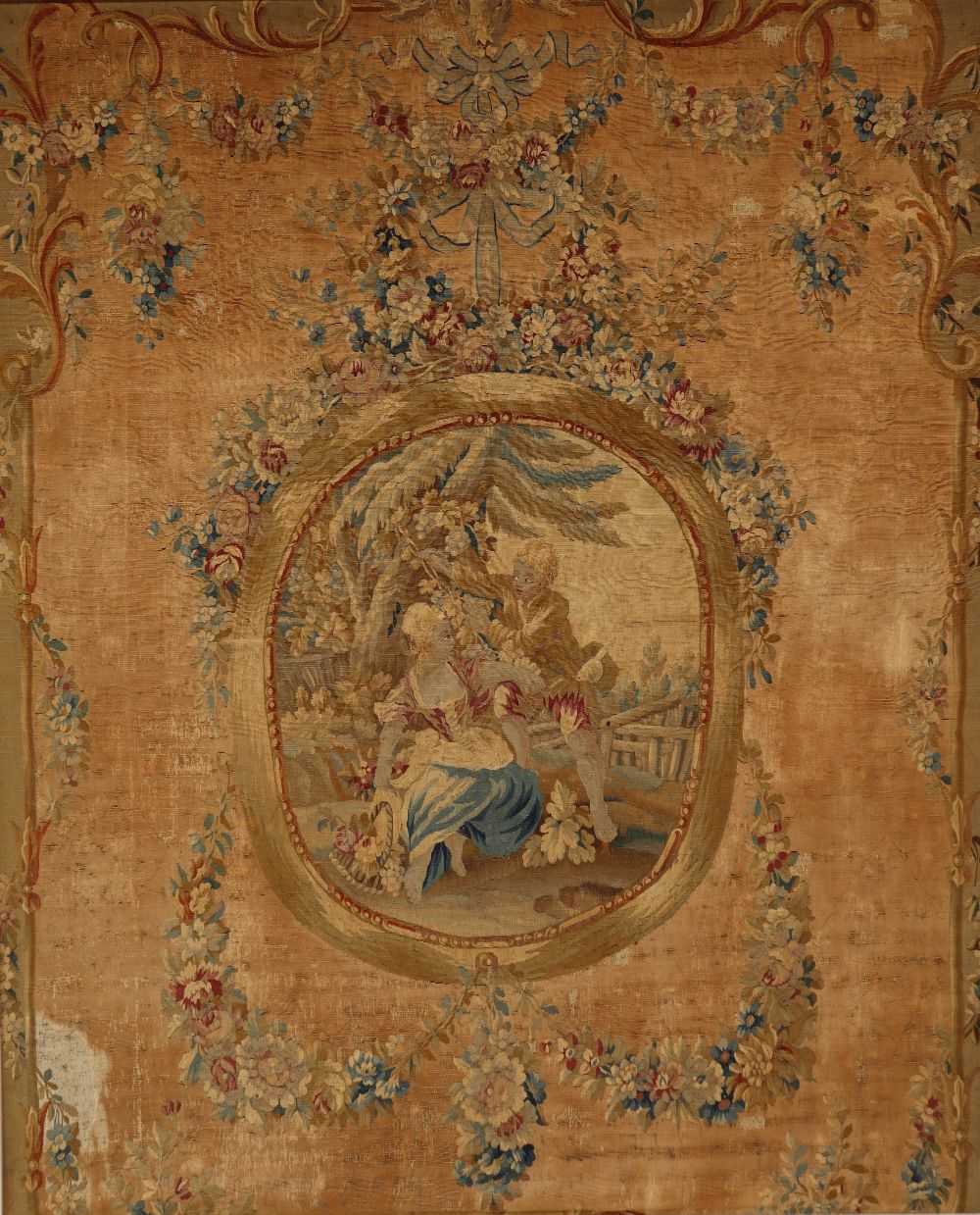 An 18th century French Aubusson medallion pastoral tapestry with a floral swag border,