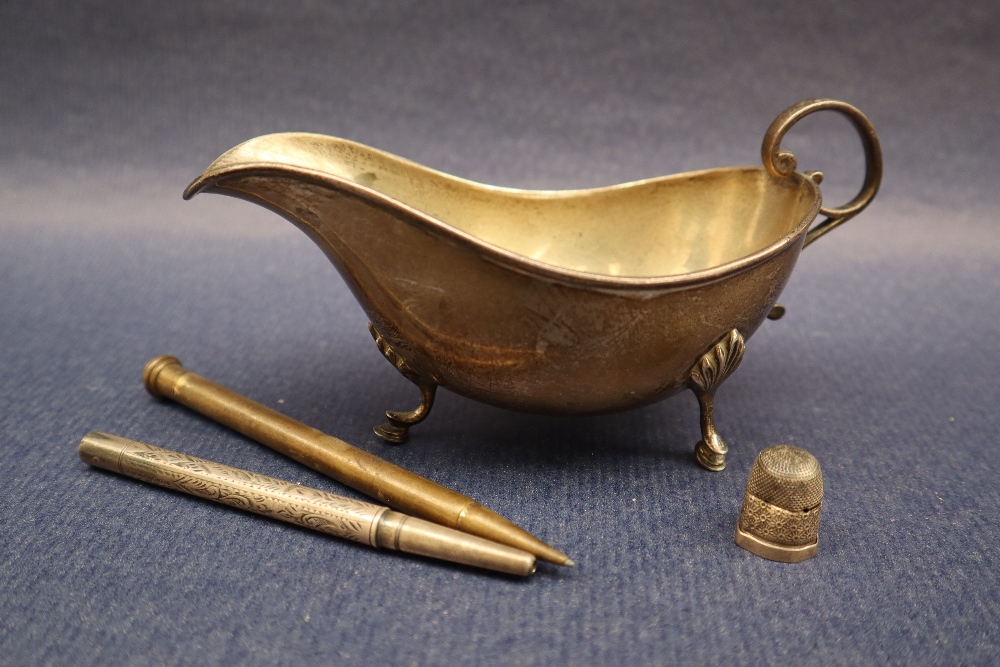 An Edward VII silver sauce boat with a scrolling handle on three legs with hoof feet, Sheffield,