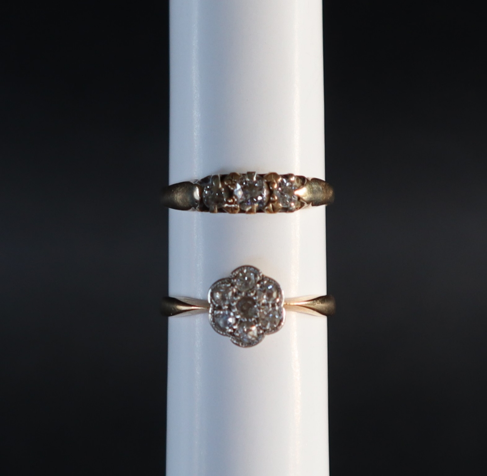 A three stone diamond ring, set with round old cut diamonds to a yellow metal setting and shank,