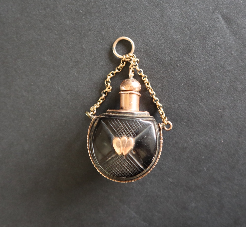 A small scent bottle the ebonised body inset and mounted in yellow metal on a chain - Image 2 of 4