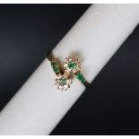 An 18ct yellow gold emerald and diamond double cluster ring set with six emeralds and twelve round