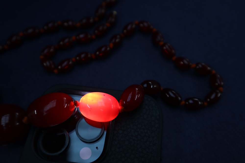 A cherry amber / bakelite beaded necklace, with graduating beads varying in size from 30mm to 10mm, - Image 5 of 9