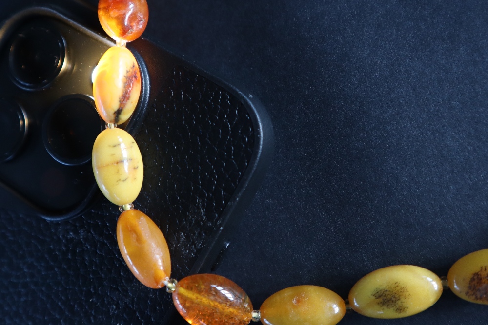 An amber bead necklace, with graduated oval beads, 63cm long, - Image 3 of 3