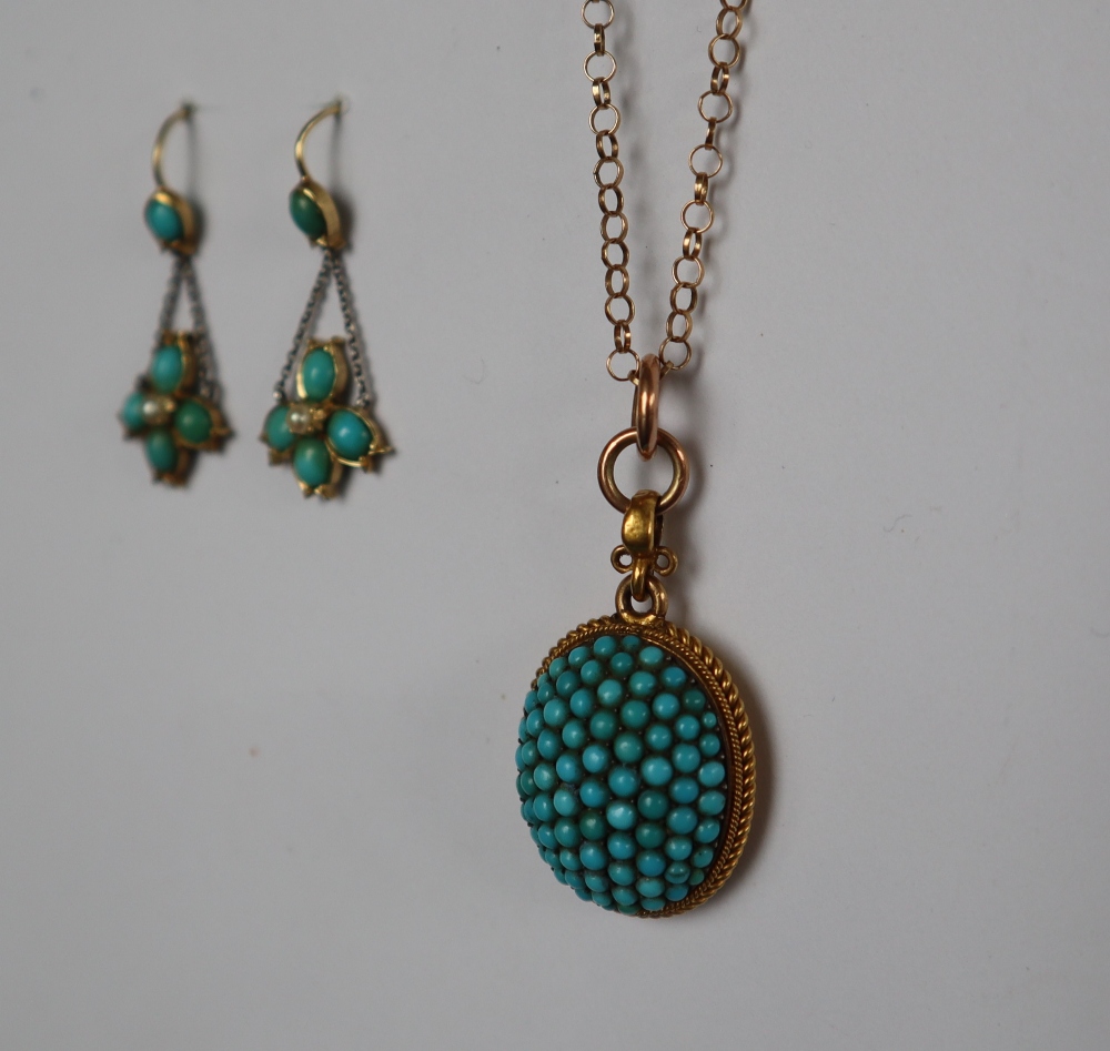 A yellow metal pendant of oval form set with turquoise on a 9ct yellow gold chain,