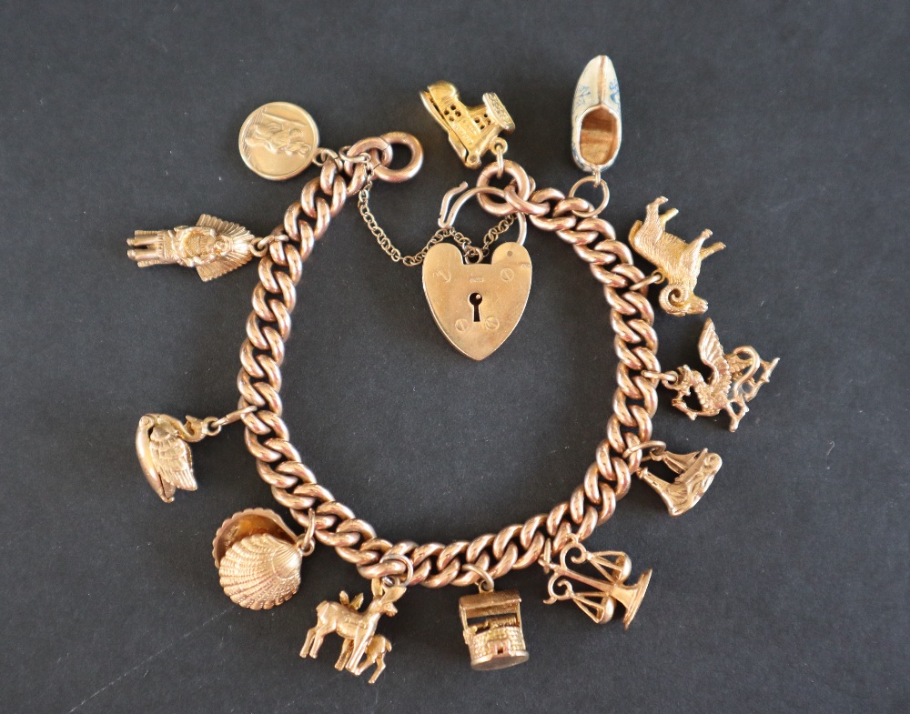 A 9ct yellow gold charm bracelet set with numerous charms including a St Christopher, Red Indian,