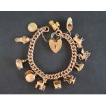 A 9ct yellow gold charm bracelet set with numerous charms including a St Christopher, Red Indian,