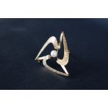 A 9ct textured yellow gold star shaped brooch, set with a central pearl, 3.