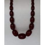 A string of cherry amber / bakelite beads,