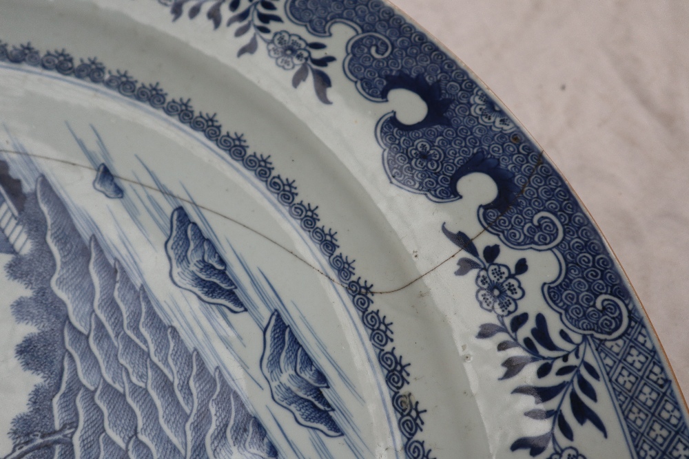 A large Chinese blue and white porcelain charger, decorated with cottages and trees on a river, - Image 3 of 5