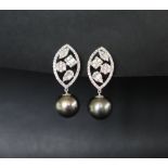 A pair of 18ct white gold drop earrings with suspended round freshwater Tahitian pearls and