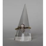 A two stone diamond ring set with old round cut diamonds to a white metal setting and yellow metal