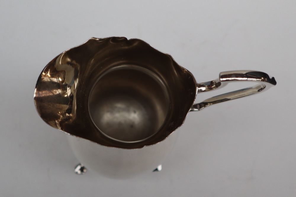 An Edward VII silver cream jug of baluster form with a scrolling handle on four feet, Sheffield, - Image 3 of 4