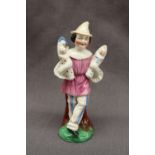 A 19th Century porcelain figure in a pink top and striped trousers holding four babies on an oval