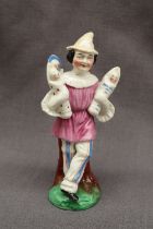 A 19th Century porcelain figure in a pink top and striped trousers holding four babies on an oval