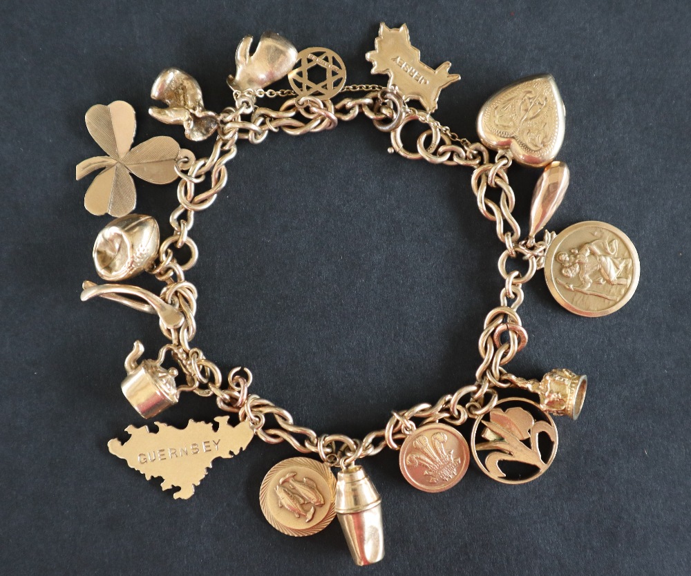 A 9ct gold bracelet with interlocking links set with numerous charms including the Prince of Wales